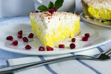 Homemade coconut cream pie in white plate with fork on light cloth napkin
