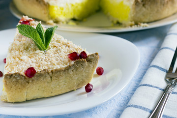 Homemade coconut cream pie in white plate with fork on light cloth napkin