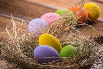 Easter eggs in nest on old wooden background