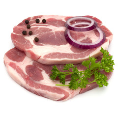 Raw pork neck chop meat with parsley herb leaves, peppercorn spices and onion slices garnish isolated on white background cutout