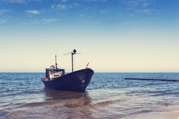 Fototapeta premium Fishing boat on the coast. Vintage toned.
