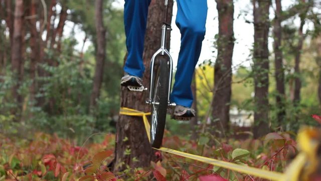 Extreme balance unicycle is riding on a tight rope or slackline