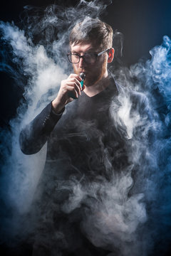 Smoking electronic cigarettes. Man in smoke