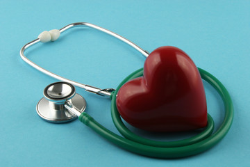 Stethoscope and heart on blue background.
