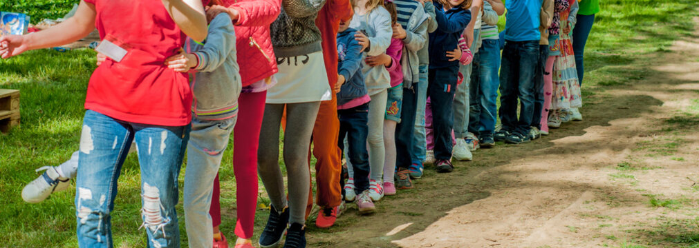 A group of uneven-aged children are going along with each other