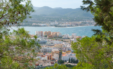 Naklejka premium Wide angle view through trees from high point on nearby hillside out to see and the familiar islands just offshore of Ibiza.