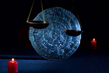 mayan calendar on black background and candles