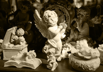 White angels with hearts for sale at Flower Market in Paris. Vintage background. Sepia.