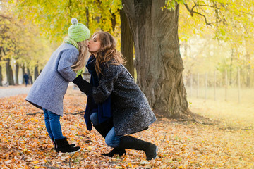 Mother walking with daughter outdoors in the autumn