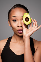 Happy healthy black asian woman with avocado fruit © Paul Hakimata