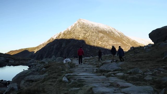 A Group of Tourists on Rocky Path in Mountains