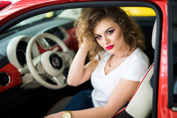 Obraz na płótnie Canvas Pretty young woman seat in her new car