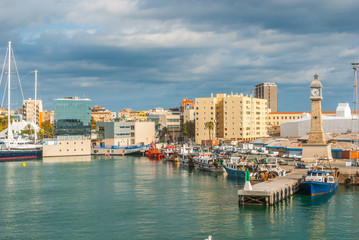 Fototapeta premium Łodzie zacumowane w porcie w Marina, Port Vell w Barcelonie, Hiszpania. Żaglówki, jachty, statki wycieczkowe i trawlery rybackie zacumowały w pobliżu miasta w ciepłej Barcelonie w listopadowe popołudnie.
