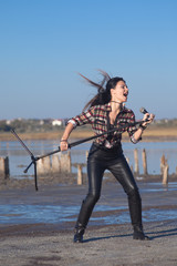 Naklejka premium Rock musician woman singing near water outside
