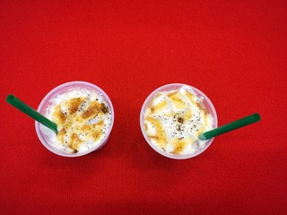 Ice coffee frappe with caramel topping on red background