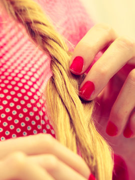 Closeup of woman doing braid on blonde hair