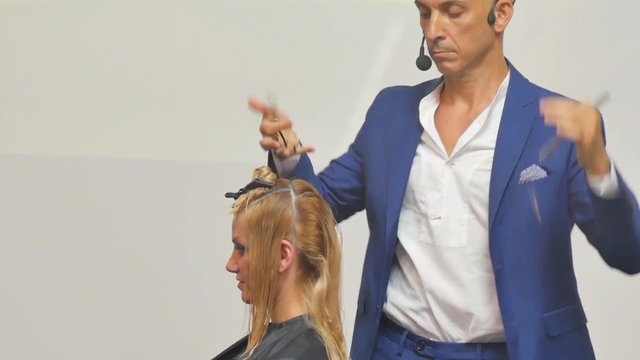 Hairdresser In Action. Barber and customers. hairstyle models for white hair. Blonde in the cabin. Work in the cabin. Barber shears white hair model client. close-up.