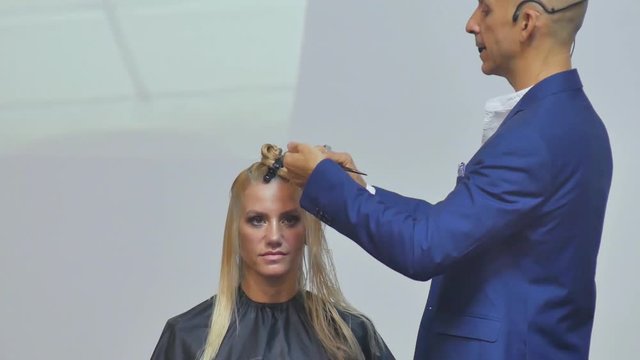 Hairdresser In Action. Barber and customers. hairstyle models for white hair. Blonde in the cabin. Work in the cabin. Barber shears white hair model client. close-up.