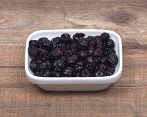 Whole organic dried cranberries on wooden vintage tray background