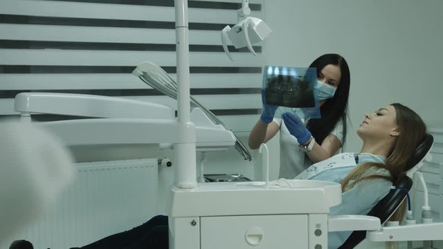 Dentist showing roentgenogram to the female patient