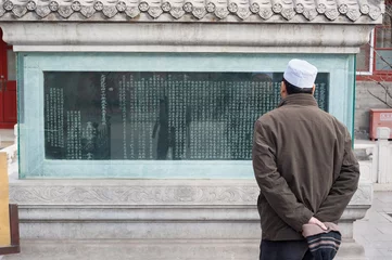 Fototapeten Man reads an inscription on an ancient stele at Niujie Mosque, Beijing, China © Stripped Pixel