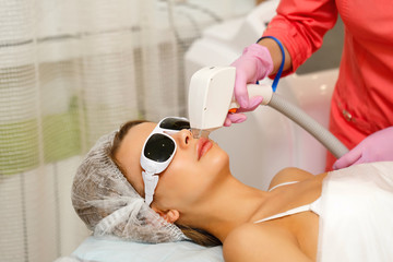 Laser hair removal on the face of a young girl. Apparatus cosmetology. Cosmetic procedures. Spa. Removing hair from the upper lip.