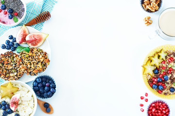 Top view of healthy breakfast food frame over white background with a place for text. Muesli and cottage cheese with blueberry and starfruit, yoghurt with chia, multi-grain cookie and coffee. 