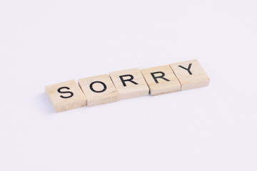 Text wooden blocks spelling the word sorry on white background