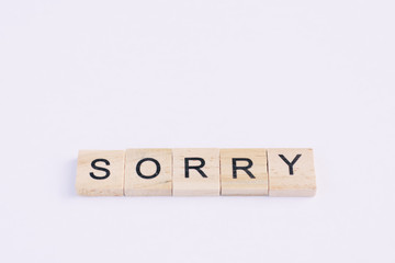 Text wooden blocks spelling the word sorry on white background
