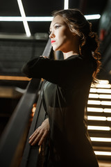 Sexy woman in black leather belts and silk gown