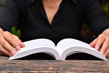person read the book on wooden table