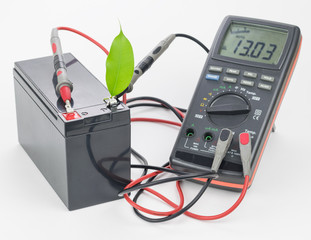 Rechargeable battery with connected measuring instrument and green leaf.