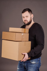 man holding pile of cardboard boxes in front