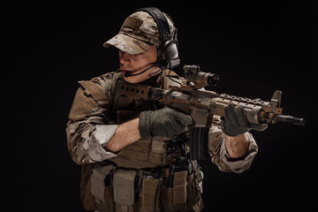 Portrait soldier or private military contractor holding sniper rifle. war, army, weapon, technology and people concept. Image on a black background.