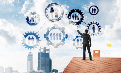 Businessman on house roof presenting teamwork and connection concept. Mixed media