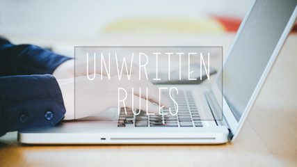 Unwritten Rules, text over young man typing on laptop at desk