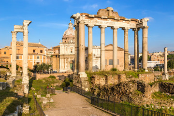 Fototapeta na wymiar Rome, Italy. Roman Forum: on the left - the ruins of the Temple of Vespasian and Titus (79 AD), on the right - the ruins of the temple of Saturn (489 BC - 283 AD)