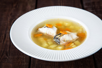 fresh fish soup with pike perch and vegetables in a white plate