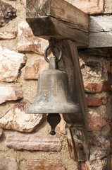 Obraz premium Small church bell closeup on old stone wall background