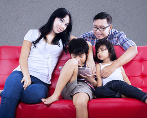 Happy family enjoy quality time on red sofa