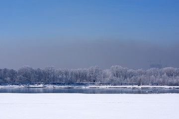 The frozen bank of the river with trees covered with hoarfrost