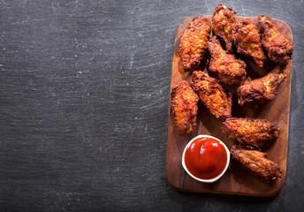 fried chicken with ketchup on dark table