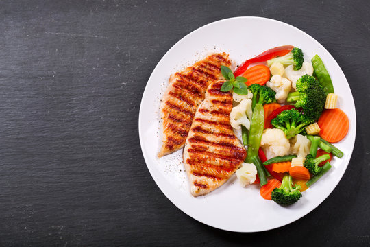 plate of grilled chicken with vegetables
