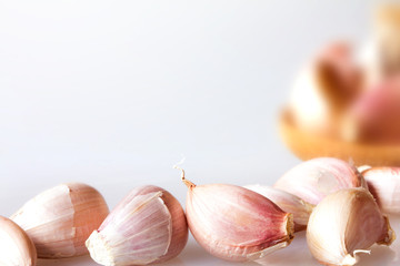 Close up garlic in a wooden spoon on white background