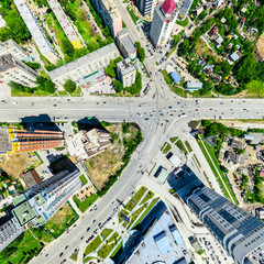 Aerial city view with crossroads and roads, houses, buildings, parks and parking lots, bridges....