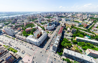 Obraz premium Aerial city view with crossroads and roads, houses, buildings, parks and parking lots, bridges. Urban landscape. Copter shot. Panoramic image.