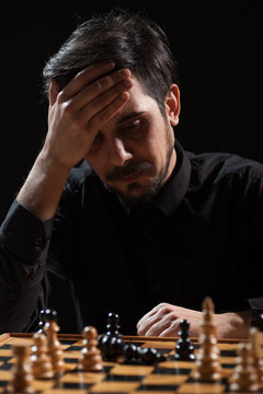 Portrait of adult man who capitulated in chess game. Focus on man.