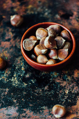 Raw chestnuts in ceramic bowl