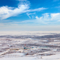 Oil derrick and road in tundra, view from above