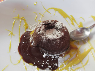 Warm chocolate fondant lava cake dessert with sweet zafferano sauce